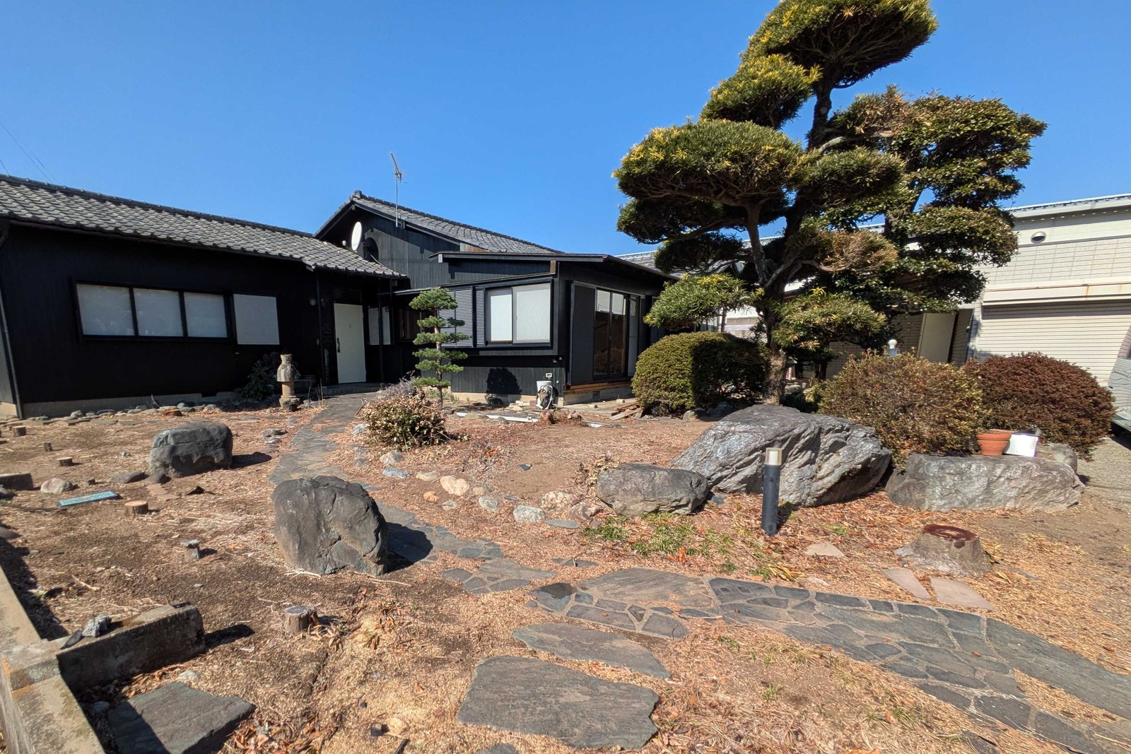 Kit-Base の外観。黒い壁と瓦屋根の古民家